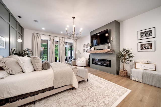 407 Hogans Branch Rd, Goodlettsville, TN 37072 - bedroom with a chandelier, wood finished floors, a large fireplace, recessed lighting, and access to outside