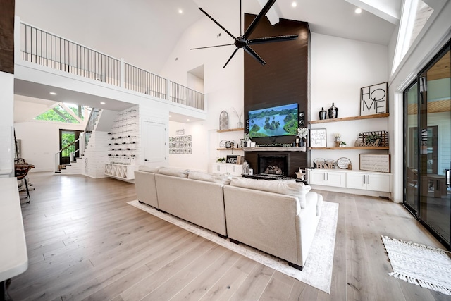407 Hogans Branch Rd, Goodlettsville, TN 37072 - living area featuring high vaulted ceiling, a ceiling fan, a fireplace, stairway, and light wood-type flooring