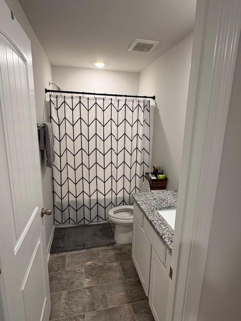 1217 Mason Dl, Columbia, TN 38401 - bathroom featuring vanity, toilet, stone finish flooring, and shower / bathtub combination with curtain