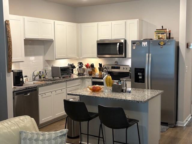 1217 Mason Dl, Columbia, TN 38401 - kitchen featuring appliances with stainless steel finishes, white cabinets, light stone countertops, and tasteful backsplash