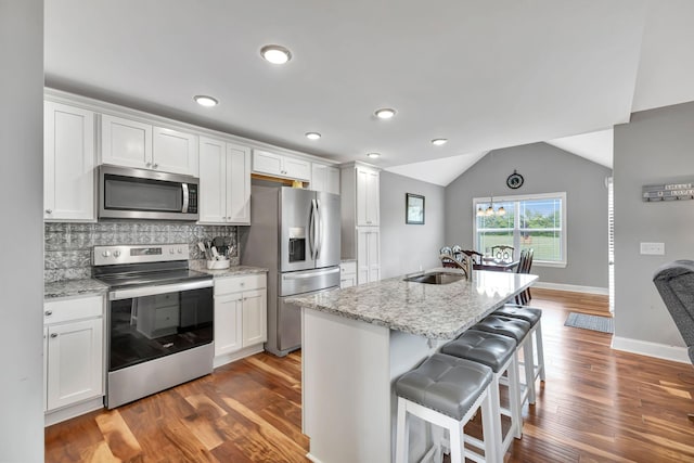 4717 Lunns Store Rd, Chapel Hill, TN 37034 - kitchen with stainless steel appliances, wood finished floors, white cabinetry, a breakfast bar, and vaulted ceiling
