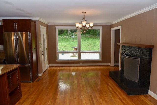 1314 Burton Valley Rd, Nashville, TN 37215 - unfurnished dining area featuring a brick fireplace, light wood-style floors, a chandelier, baseboards, and ornamental molding