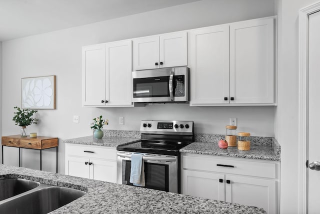 148 Victory Cir, Ashland City, TN 37015 - kitchen with stainless steel appliances, white cabinets, light stone counters, and a sink