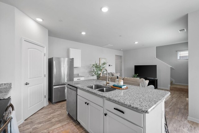 148 Victory Cir, Ashland City, TN 37015 - kitchen with stainless steel appliances, a sink, a kitchen island with sink, white cabinets, and recessed lighting