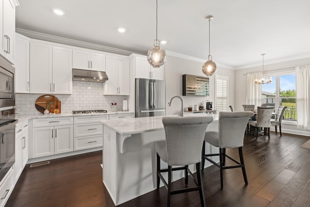 290 Academy Rd, Lebanon, TN 37087 - kitchen with appliances with stainless steel finishes, under cabinet range hood, crown molding, a chandelier, and dark wood-style flooring