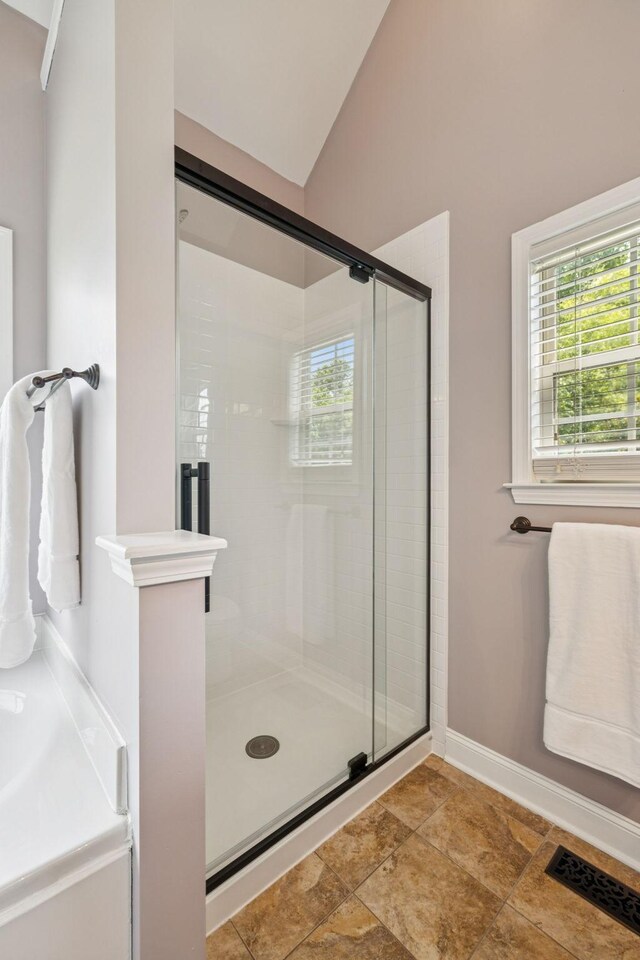 2090 Lequire Ln, Spring Hill, TN 37174 - full bathroom featuring a stall shower, lofted ceiling, baseboards, and stone finish flooring