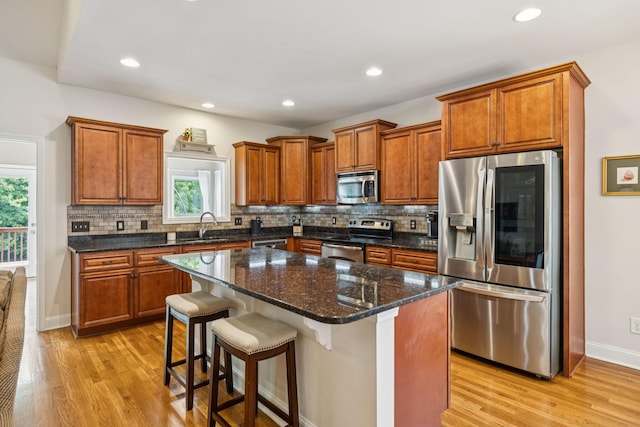 2090 Lequire Ln, Spring Hill, TN 37174 - kitchen with stainless steel appliances, light wood-style flooring, a center island, decorative backsplash, and recessed lighting