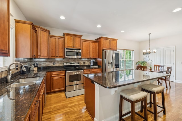 2090 Lequire Ln, Spring Hill, TN 37174 - kitchen with appliances with stainless steel finishes, a sink, light wood-type flooring, brown cabinetry, and recessed lighting