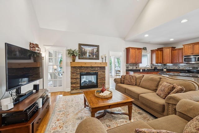 2090 Lequire Ln, Spring Hill, TN 37174 - living room featuring light wood-style flooring, vaulted ceiling, recessed lighting, and a stone fireplace
