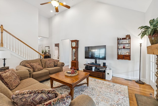 2090 Lequire Ln, Spring Hill, TN 37174 - living room featuring a ceiling fan, stairs, light wood-style floors, high vaulted ceiling, and baseboards