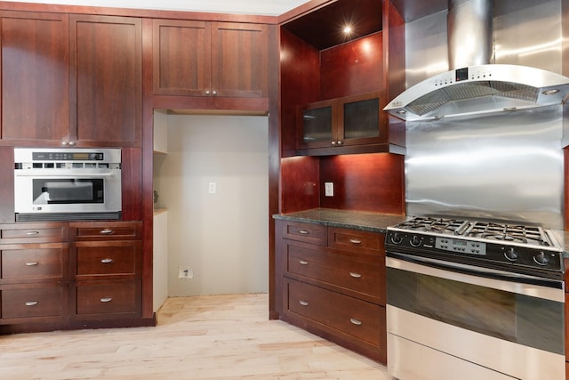 1107 Stonebridge Park Dr, Franklin, TN 37069 - kitchen with appliances with stainless steel finishes, wall chimney range hood, light wood finished floors, glass insert cabinets, and decorative backsplash