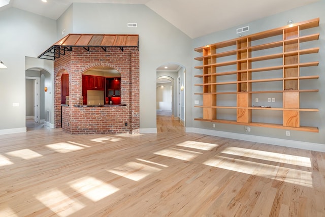 1107 Stonebridge Park Dr, Franklin, TN 37069 - unfurnished living room featuring high vaulted ceiling, wood finished floors, arched walkways, and baseboards
