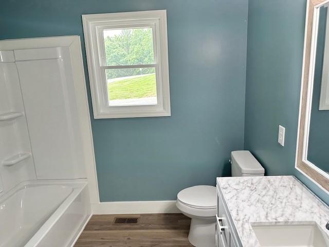 807 Poplar Dr, Centerville, TN 37033 - full bath with toilet, baseboards, wood finished floors, vanity, and  shower combination