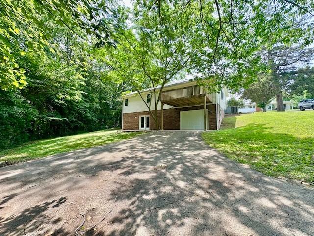 807 Poplar Dr, Centerville, TN 37033 - view of front facade with a front lawn, driveway, a carport, a wooden deck, and a garage