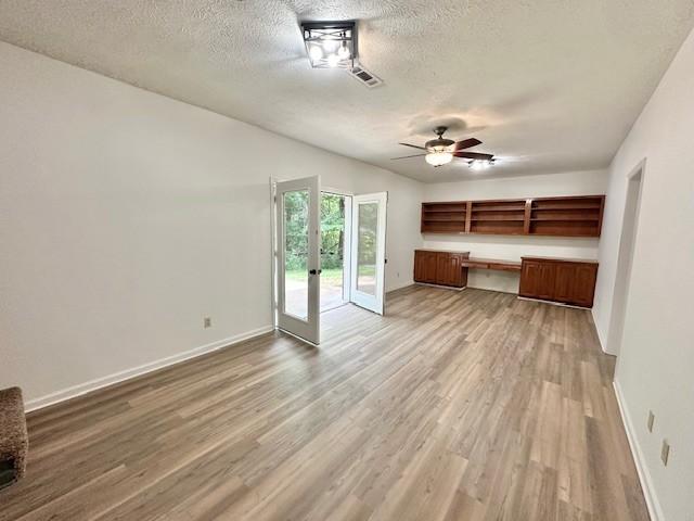 807 Poplar Dr, Centerville, TN 37033 - unfurnished living room featuring french doors, wood finished floors, a textured ceiling, baseboards, and a ceiling fan