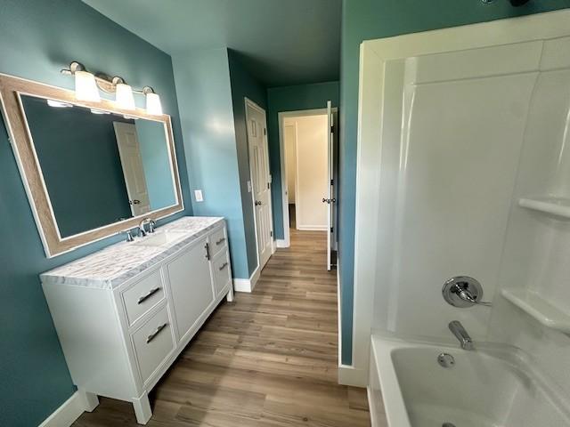 807 Poplar Dr, Centerville, TN 37033 - bathroom featuring baseboards, vanity, wood finished floors, and shower / bathtub combination