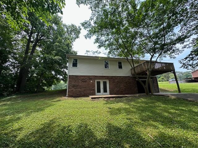 807 Poplar Dr, Centerville, TN 37033 - back of property featuring french doors, a lawn, a deck, and brick siding