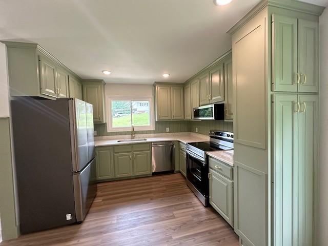 807 Poplar Dr, Centerville, TN 37033 - kitchen featuring stainless steel appliances, a sink, green cabinets, light countertops, and light wood-style floors