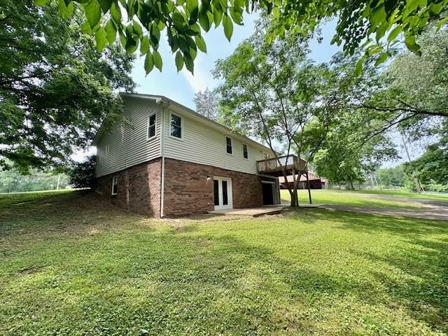 807 Poplar Dr, Centerville, TN 37033 - view of home's exterior featuring a wooden deck, a yard, and brick siding