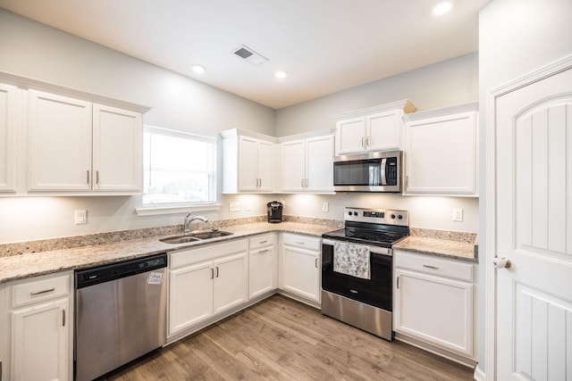 1110 Colonel Reuben Searcy Ct, Murfreesboro, TN 37129 - kitchen with appliances with stainless steel finishes, a sink, white cabinets, light wood-type flooring, and recessed lighting