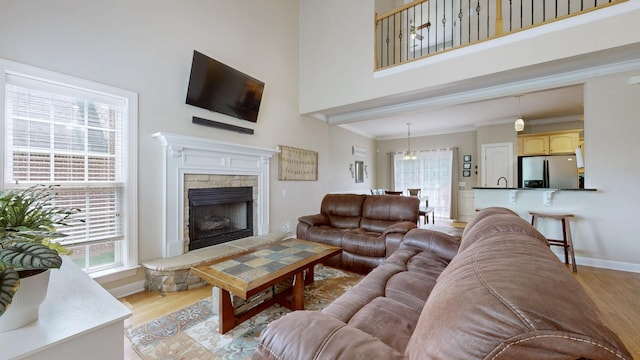 4015 Sleepyhollow Way, Mount Juliet, TN 37122 - living room with light wood finished floors, a towering ceiling, a fireplace, crown molding, and baseboards
