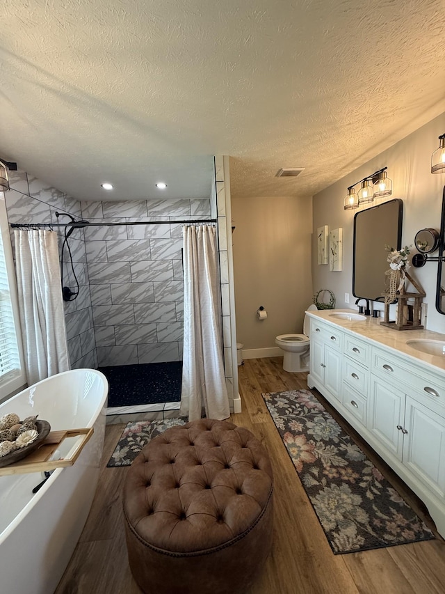 285 Shrum Ln, Lafayette, TN 37083 - full bath with a soaking tub, wood finished floors, a shower stall, toilet, and a textured ceiling