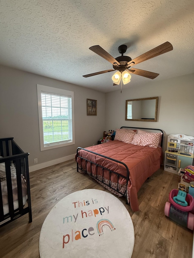 285 Shrum Ln, Lafayette, TN 37083 - bedroom featuring wood finished floors, a textured ceiling, baseboards, and ceiling fan