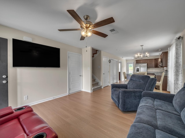 201 Quarry Overlook Way, Clarksville, TN 37043 - living area with stairs, a chandelier, a ceiling fan, light wood-style floors, and baseboards