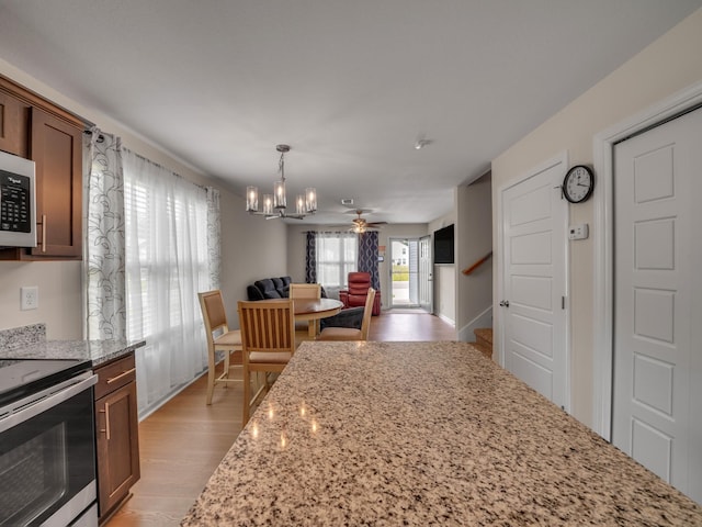 201 Quarry Overlook Way, Clarksville, TN 37043 - kitchen featuring stainless steel electric range, a chandelier, light wood-type flooring, light stone countertops, and open floor plan