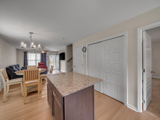 201 Quarry Overlook Way, Clarksville, TN 37043 - kitchen featuring open floor plan, a chandelier, light wood-style flooring, a kitchen island, and light stone countertops