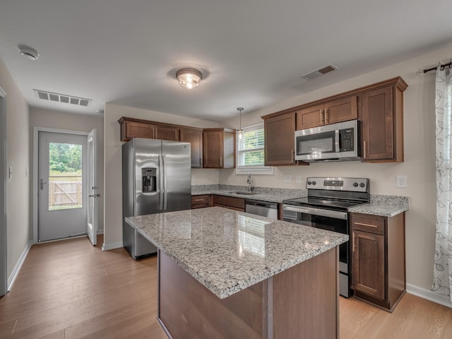201 Quarry Overlook Way, Clarksville, TN 37043 - kitchen with stainless steel appliances, a sink, light wood-style flooring, baseboards, and a center island