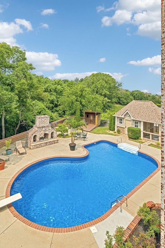 226 Hidden Harbour Dr, Mount Juliet, TN 37122 - outdoor pool with a patio area, an outdoor stone fireplace, a diving board, an outbuilding, and a storage structure