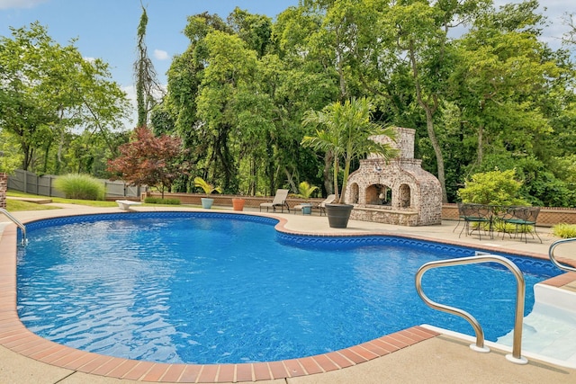 226 Hidden Harbour Dr, Mount Juliet, TN 37122 - swimming pool featuring an outdoor stone fireplace, a patio area, and view of wooded area