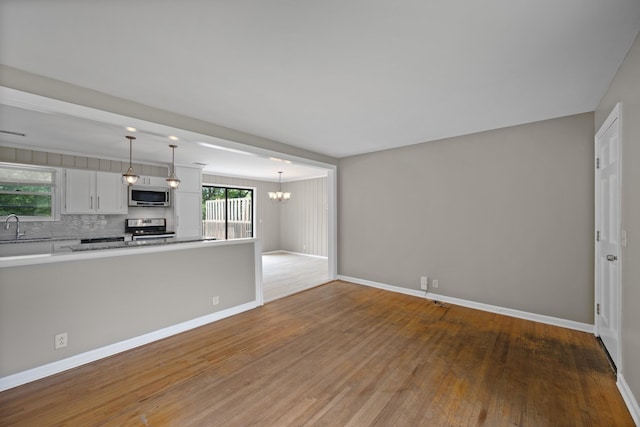 109 Hazelwood Dr, Hendersonville, TN 37075 - unfurnished living room with a sink, wood finished floors, a chandelier, and baseboards