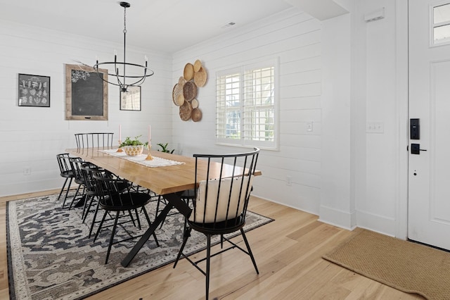 7546 Delancey Dr, College Grove, TN 37046 - dining room with a chandelier, light wood-style floors, baseboards, and wood walls