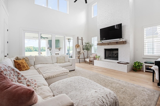 7546 Delancey Dr, College Grove, TN 37046 - living room featuring ceiling fan, wood finished floors, a high ceiling, and a fireplace