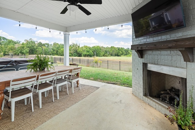 7546 Delancey Dr, College Grove, TN 37046 - fenced backyard featuring an outdoor brick fireplace, a patio, a ceiling fan, outdoor dining space, and view of wooded area