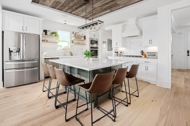7546 Delancey Dr, College Grove, TN 37046 - kitchen featuring appliances with stainless steel finishes, custom range hood, open shelves, a center island, and decorative backsplash