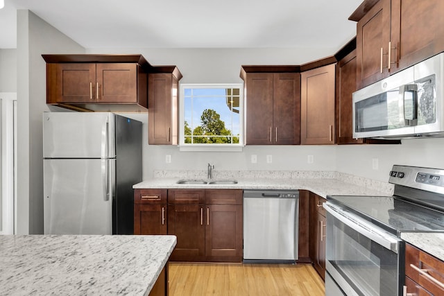 1081 Wells Way, Spring Hill, TN 37174 - kitchen with appliances with stainless steel finishes, a sink, light stone counters, and light wood-style flooring