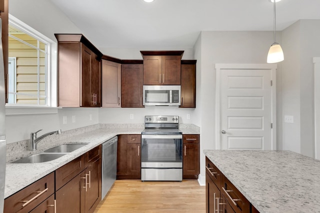 1081 Wells Way, Spring Hill, TN 37174 - kitchen featuring stainless steel appliances, light wood-style flooring, a sink, light stone counters, and pendant lighting