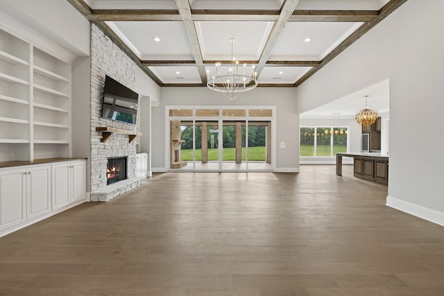 724 Bradshaw Rd, Lebanon, TN 37087 - unfurnished living room with a chandelier, a stone fireplace, baseboards, wood finished floors, and beam ceiling