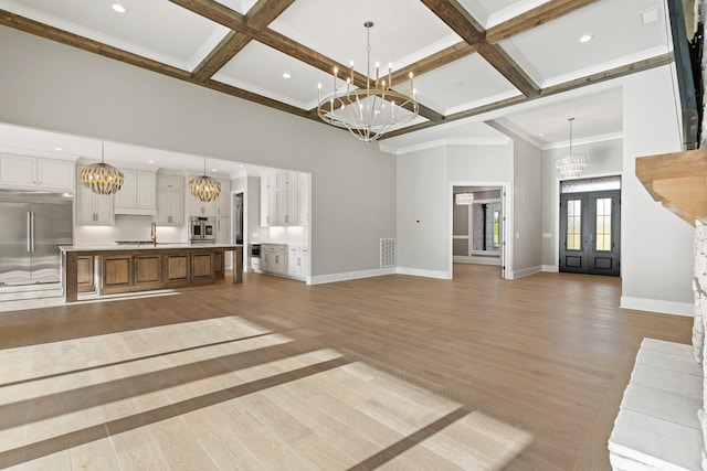 724 Bradshaw Rd, Lebanon, TN 37087 - unfurnished living room with a chandelier, a high ceiling, baseboards, light wood-style floors, and coffered ceiling