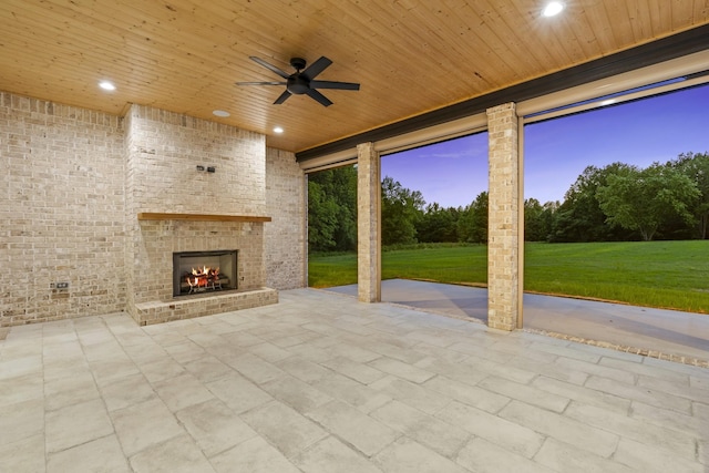 724 Bradshaw Rd, Lebanon, TN 37087 - patio terrace at dusk with an outdoor brick fireplace, a patio area, ceiling fan, and a yard