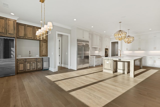 724 Bradshaw Rd, Lebanon, TN 37087 - kitchen with appliances with stainless steel finishes, a chandelier, light countertops, wood finished floors, and beverage cooler