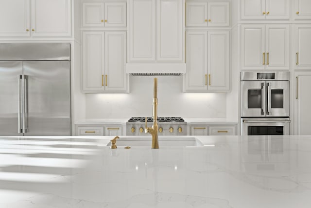 724 Bradshaw Rd, Lebanon, TN 37087 - kitchen with stainless steel appliances, white cabinets, and light stone counters