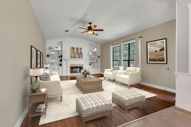 4132 Philhall Pkwy, Antioch, TN 37013 - living area with vaulted ceiling, ceiling fan, built in shelves, baseboards, and a glass covered fireplace