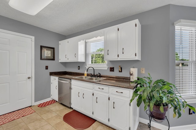 1545 Carthage Hwy, Lebanon, TN 37087 - kitchen with stainless steel dishwasher, a sink, dark countertops, white cabinets, and baseboards