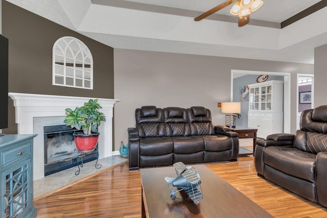 1545 Carthage Hwy, Lebanon, TN 37087 - living area with ceiling fan, a tray ceiling, light wood-style floors, and a fireplace with flush hearth