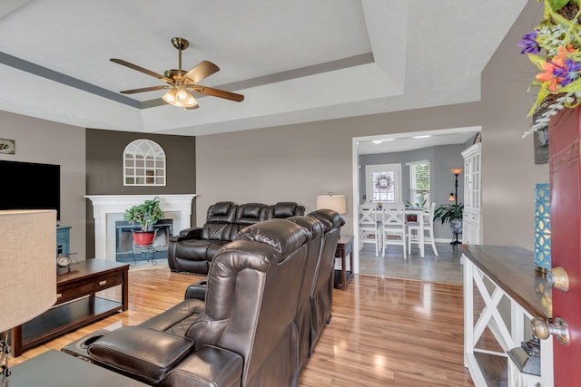 1545 Carthage Hwy, Lebanon, TN 37087 - living room featuring a raised ceiling, ceiling fan, a glass covered fireplace, light wood-style floors, and baseboards