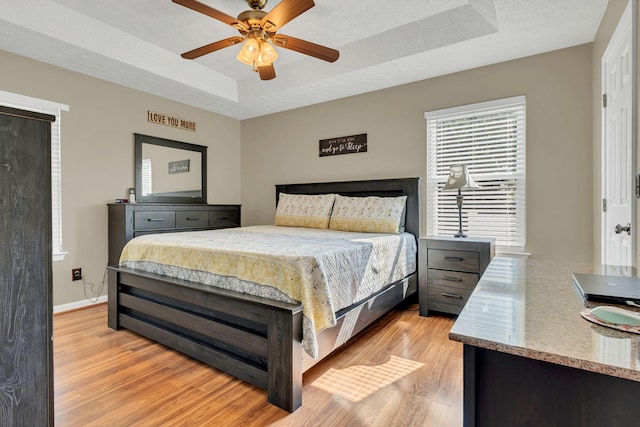 1545 Carthage Hwy, Lebanon, TN 37087 - bedroom with light wood-type flooring, a tray ceiling, baseboards, and ceiling fan